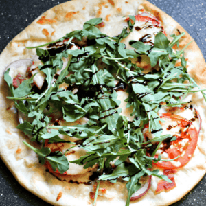 BLT Pizza Recipe - Easy Weeknight Meal. Topped with bacon, arugula, and tomatoes. #pizzarecipeeasy #bltpizza #weeknightmealidea