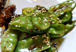 Sesame Snap Peas on white plate with rice and beef in background