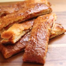 Pepperoni bread sticks on a wooden board