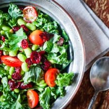 Salad in a white bowl with additional white bowl containing Disney's Ohana honey lime dressing