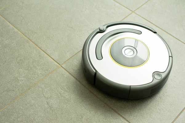 Roomba running across a kitchen floor