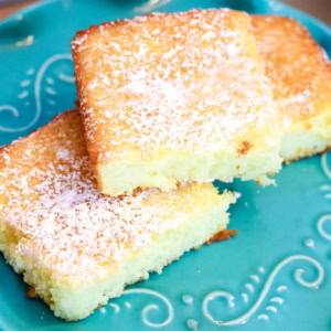Overhead view of 3 lemon angel food cake bars stacked on a turquoise cake stand
