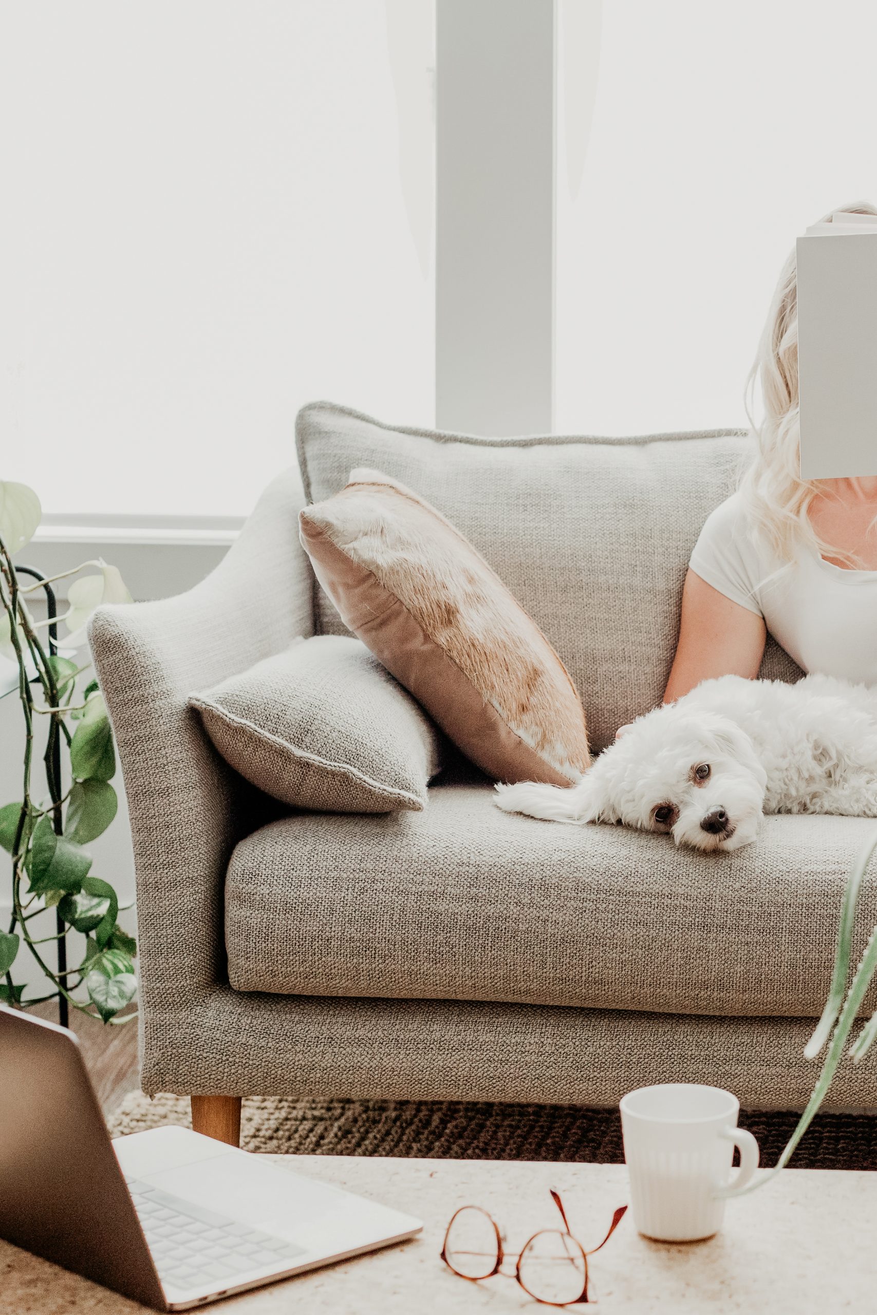 woman relaxing with her dog while reading