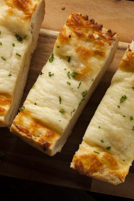 Easy Cheesy Garlic Bread slices on a cutting board