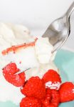 close up of a fork filled with bavarian cream, angel food cake, and a raspberry