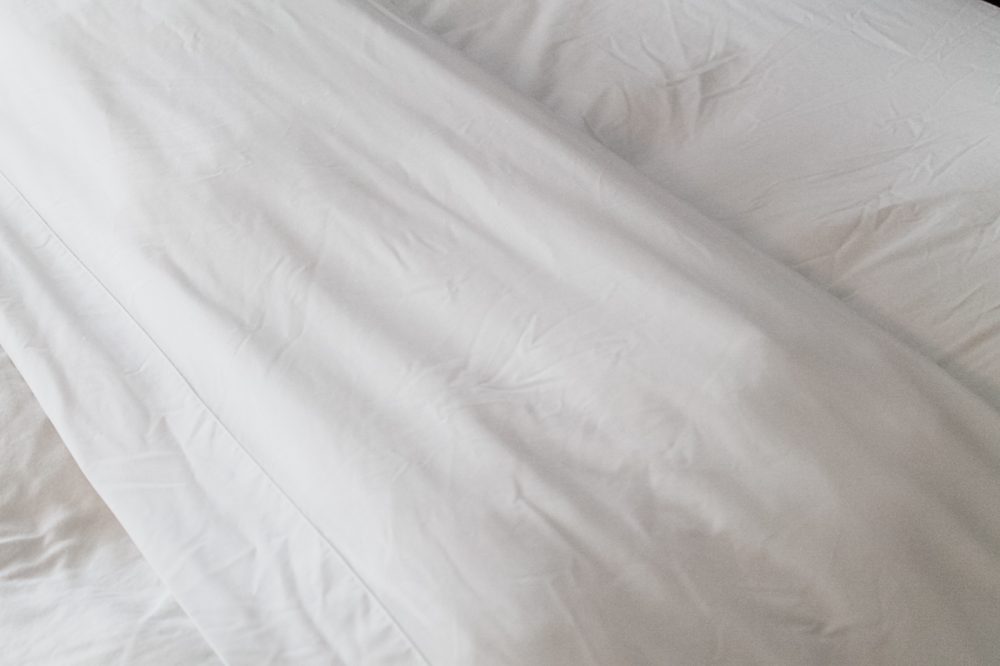 close up of flat sheet and duvet folded back on a bed