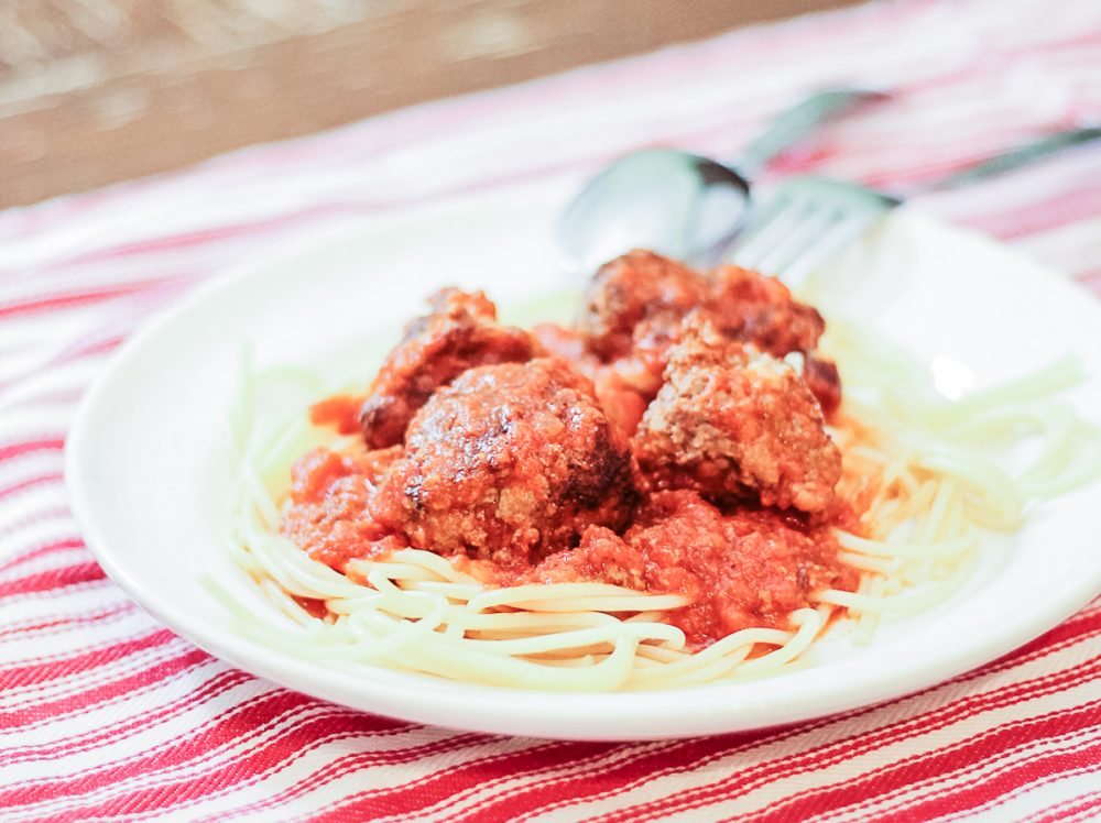 Close-up of a plate of homemade meatballs on a bed of noodles