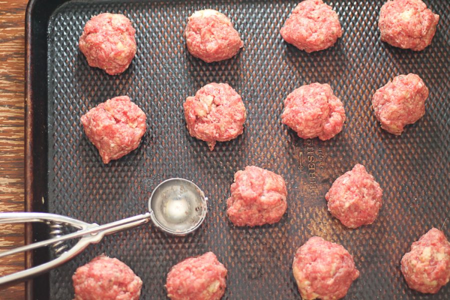uncooked meatballs on a baking sheet