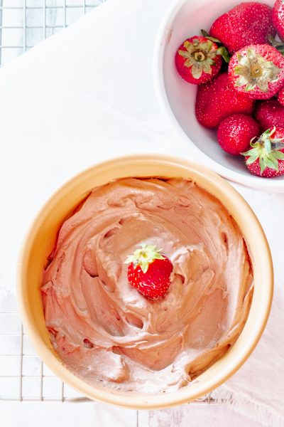 bowl of easy chocolate fruit dip next to a bowl of strawberries