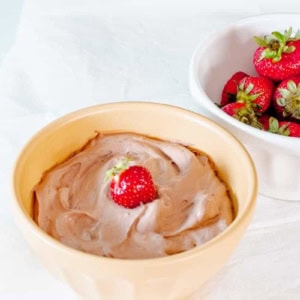 bowl of 3-ingredient chocolate fruit dip next to a bowl of strawberries