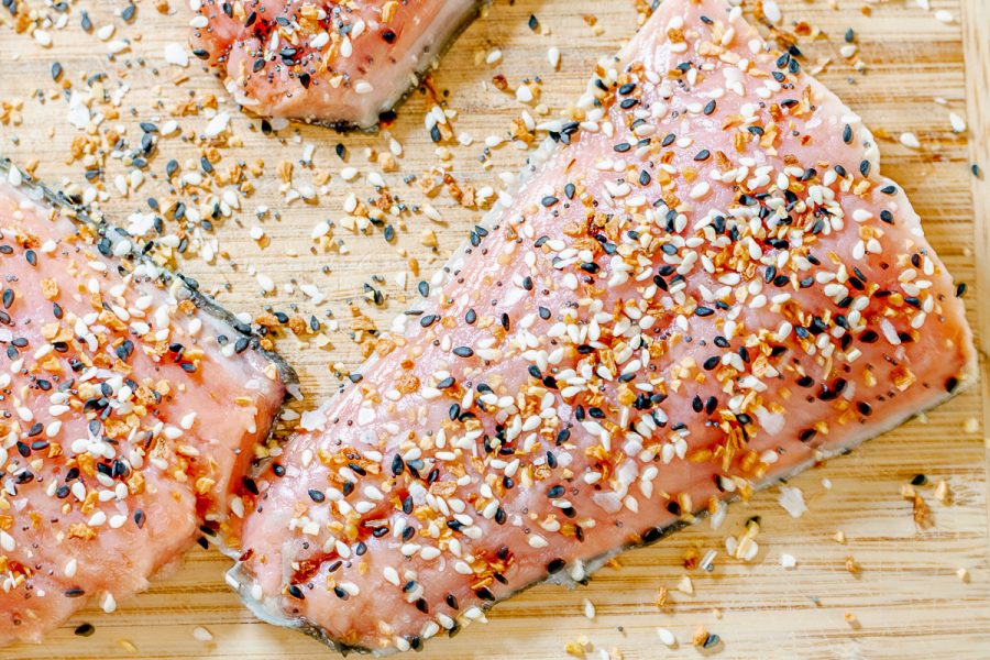 salmon filets on a cutting board sprinkled with everything bagel seasoning