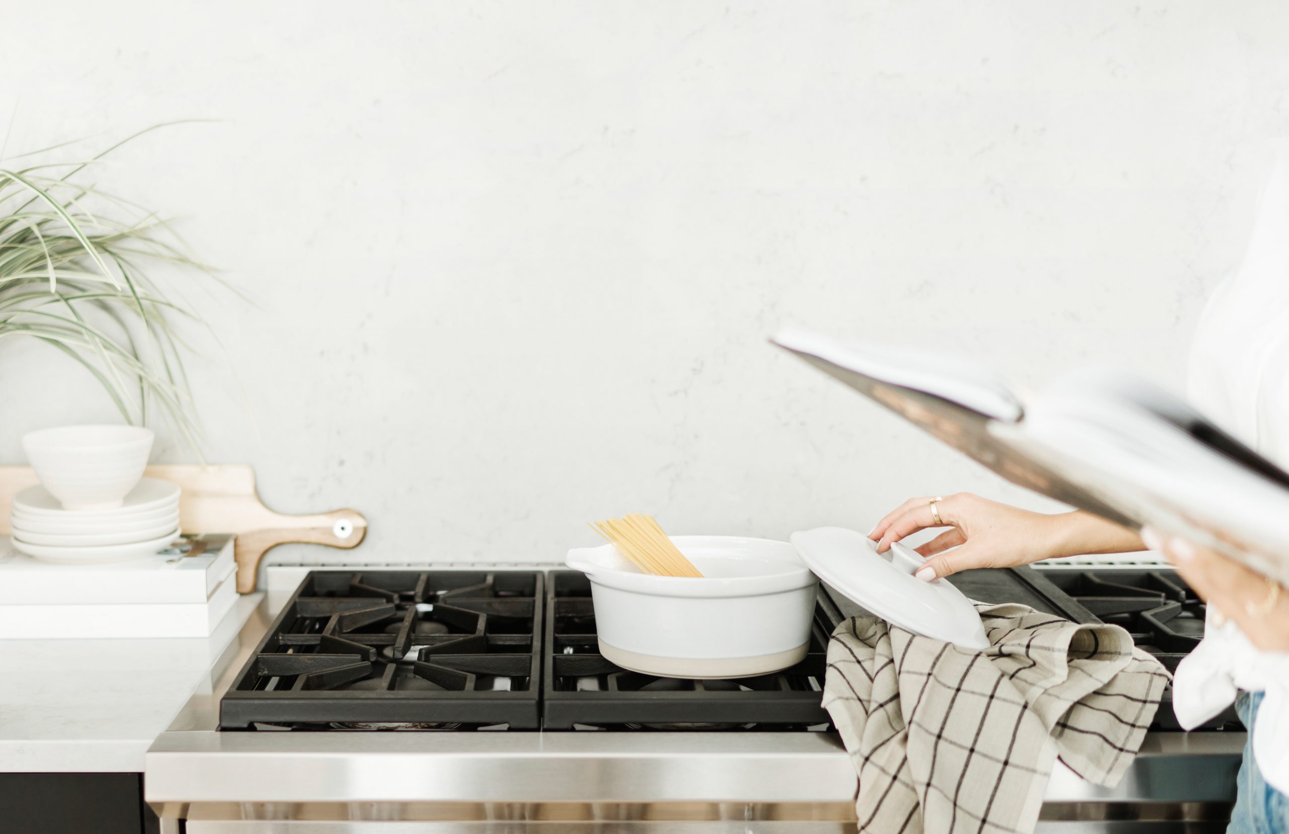 non descript woman cooking a cozy meal of pasta at a stove top