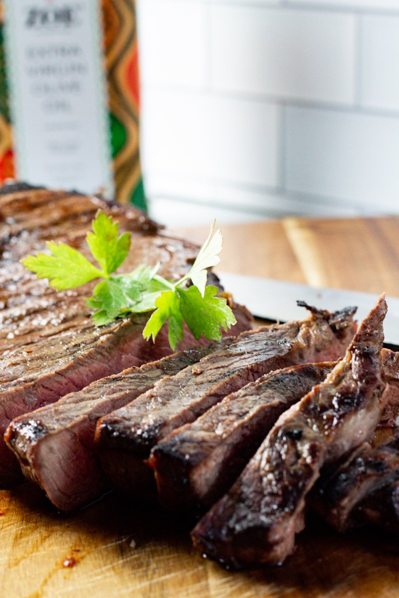 sliced marinated beef on a wooden cutting board