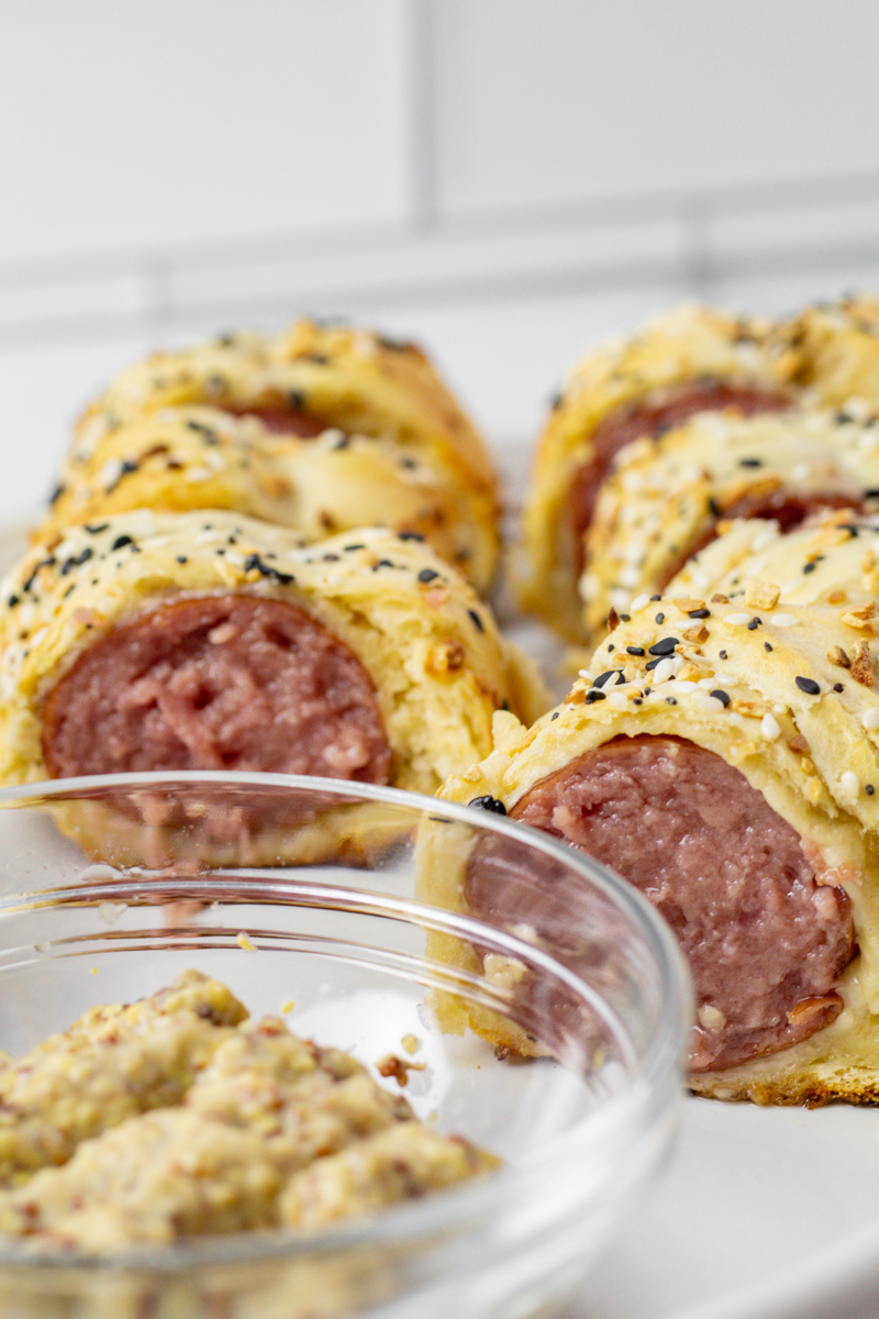 stone ground mustard and everything bagel sausage bites on a white plate