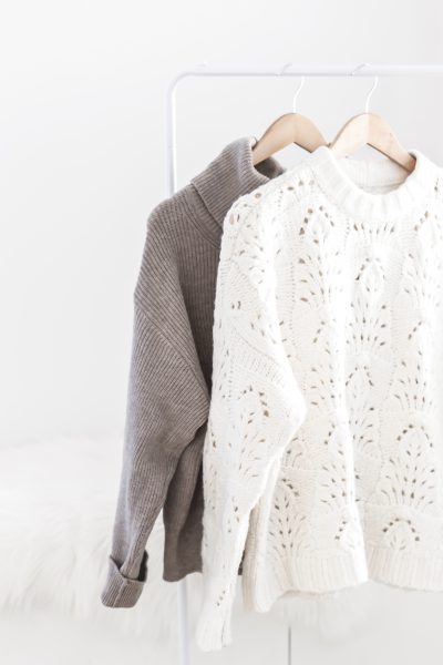 two cozy sweaters on hangers