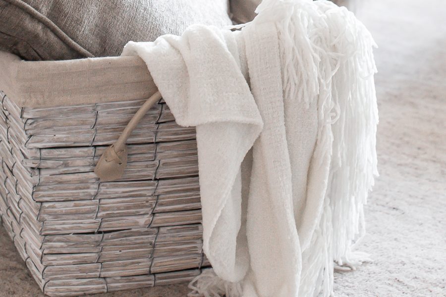 hygge wicker basket filled with pillows and cozy blankets