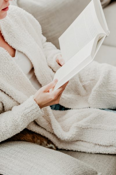 non-descript woman in a cozy sweater reading