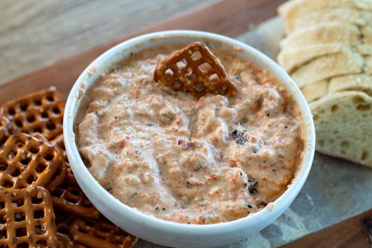 bowl of roasted vegetable dip with pretzles and sliced bread