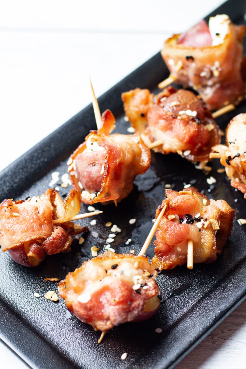 goat cheese, bacon, potato, and everything but the bagel seasoning appetizers on a black serving tray
