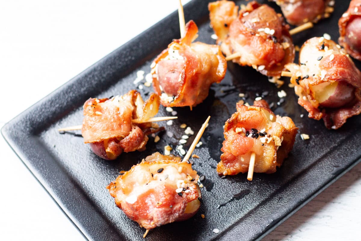 goat cheese, bacon, potato, and everything but the bagel seasoning appetizers on a black serving tray