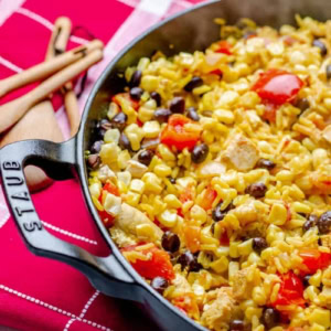 Staub pan with southwest chicken and rice on a red and white checkered placemat