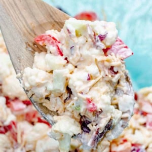 bacon cheddar potluck cauliflower salad on a wooden spoon