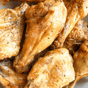 A pile of honey mustard chicken wings on a white platter