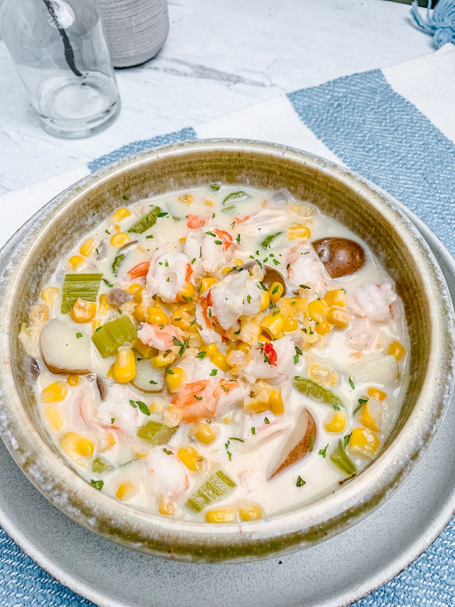 bowl of shrimp corn chowder with potatoes on a placemat