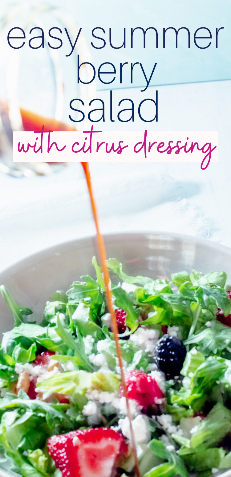 Citrus Salad Dressing being poured over a bowl of lettuce and berry salad