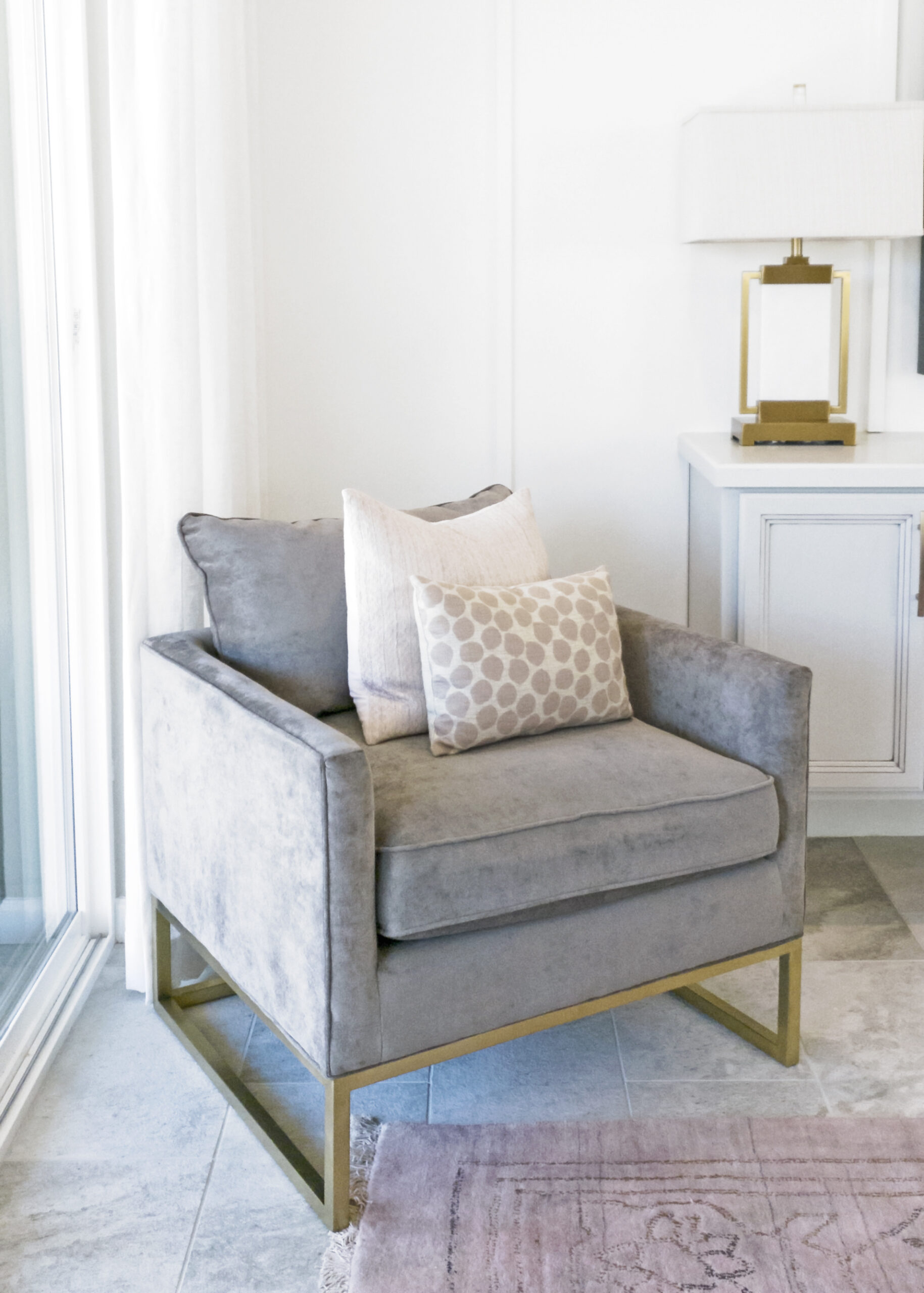 chair with throw pillows in a cozy bedroom