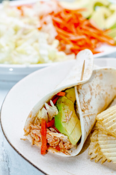 buffalo chicken wrap and potato chips on a white plate