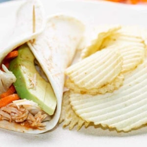 buffalo chicken wrap and potato chips on a white plate