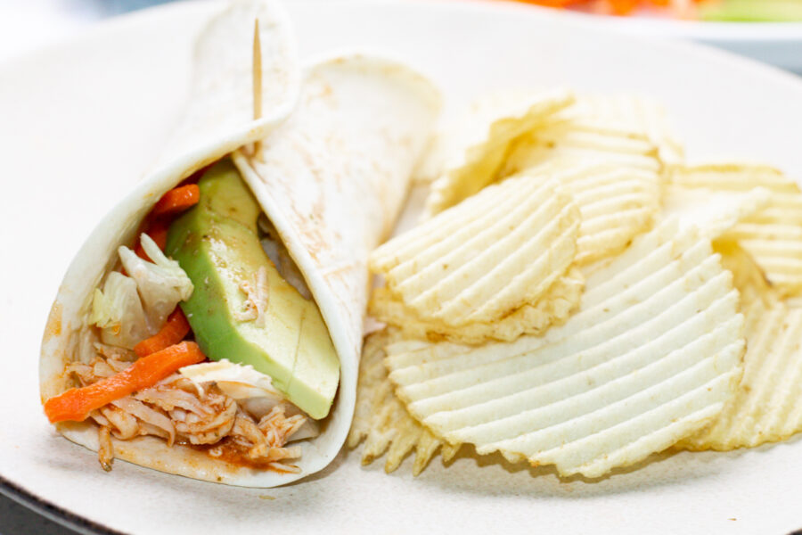 buffalo chicken wrap and potato chips on a white plate