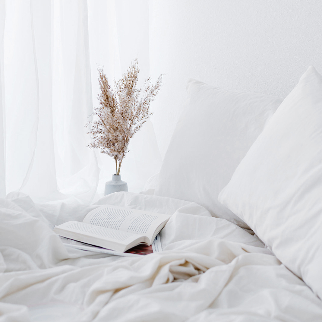 unmade cozy bed with a book