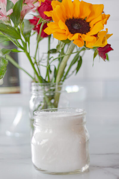 mason jar of bath salts and a bouquet of flowers