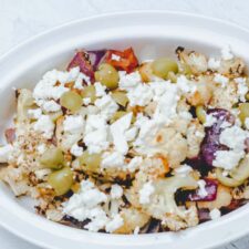 Serving pan with roasted Mediterranean Roasted Cauliflower, olive, feta, and red onions