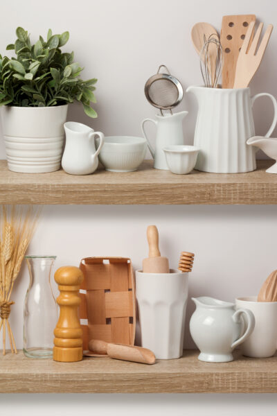 Kitchen utensils and dishware on wooden shelf. Kitchen interior background