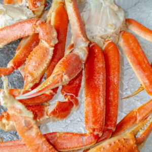 Instant pot crab legs on a clear tray with a ramakin of melted butter