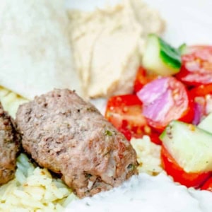 close up of a Kafta Bowl with beef, humus, tzatziki sauce, and cucumber tomato salad