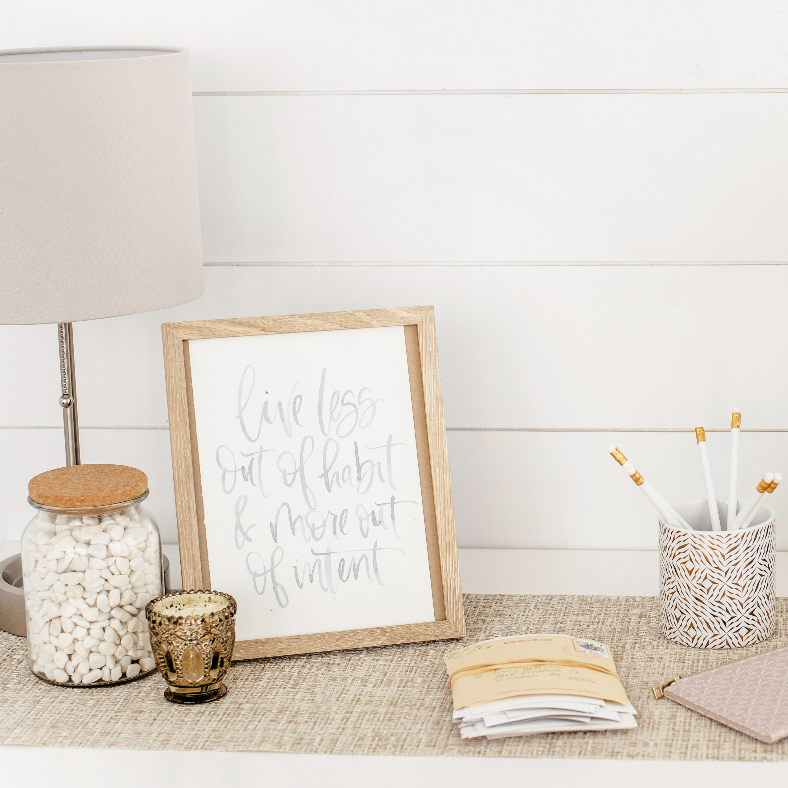 lamp, decor, and a bundle of mail on a table