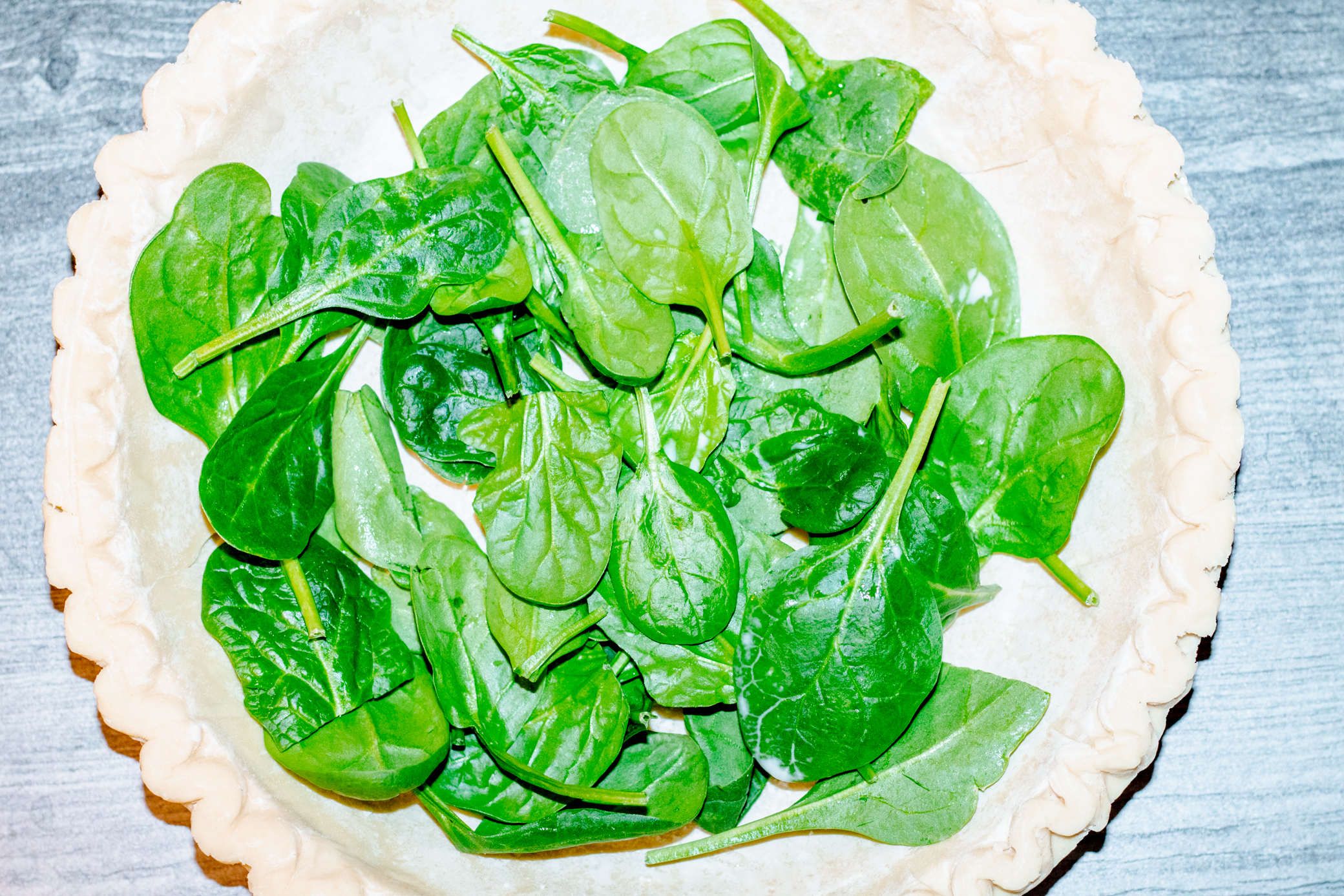 pie crust filled with baby spinach leaves