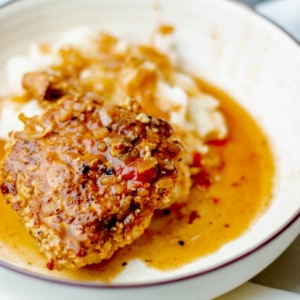 close up of turkey salisbury steak patty with gravy in a bowl with mashed potatoes