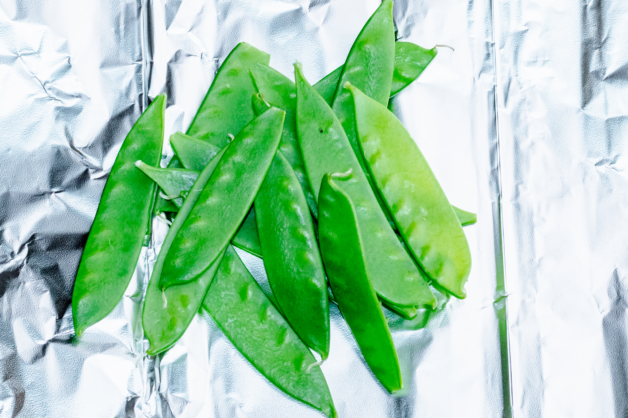 pile of snow peas on a piece of foil