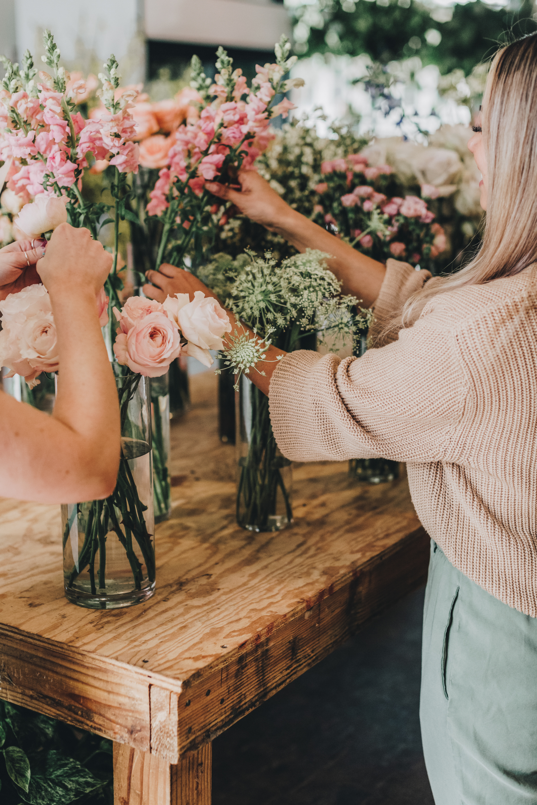 non descript women arranging vases of flowers