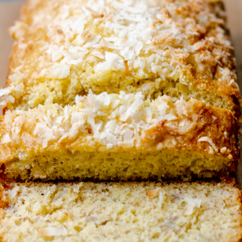 overhead view of a sliced loaf of cake mix banana bread with coconut sprinkled on top