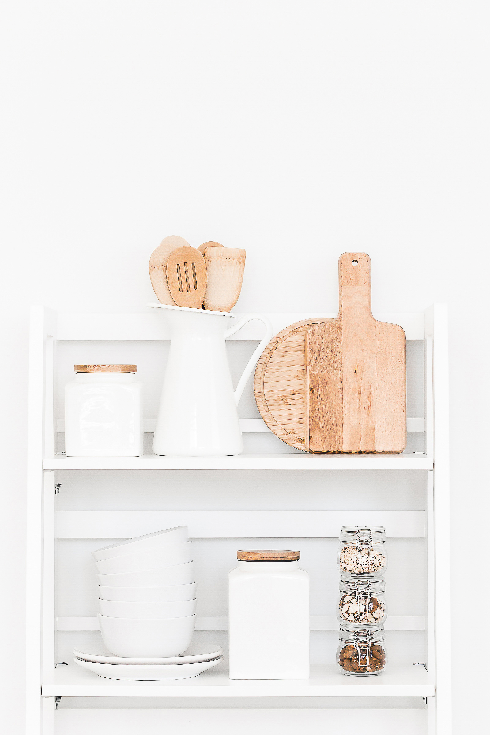 shelf with organized kitchen utensils and canisters and cutting boards