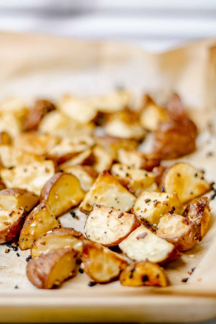 a pan lined with parchment paper and filled with roasted everything bagel potatoes