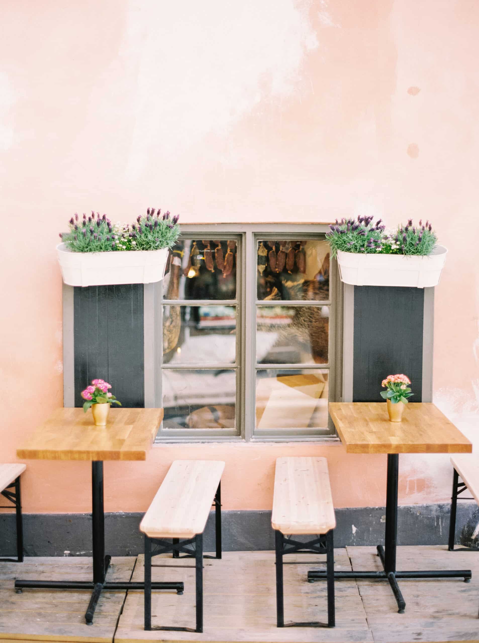 cafe table and benches next to a stucco building 