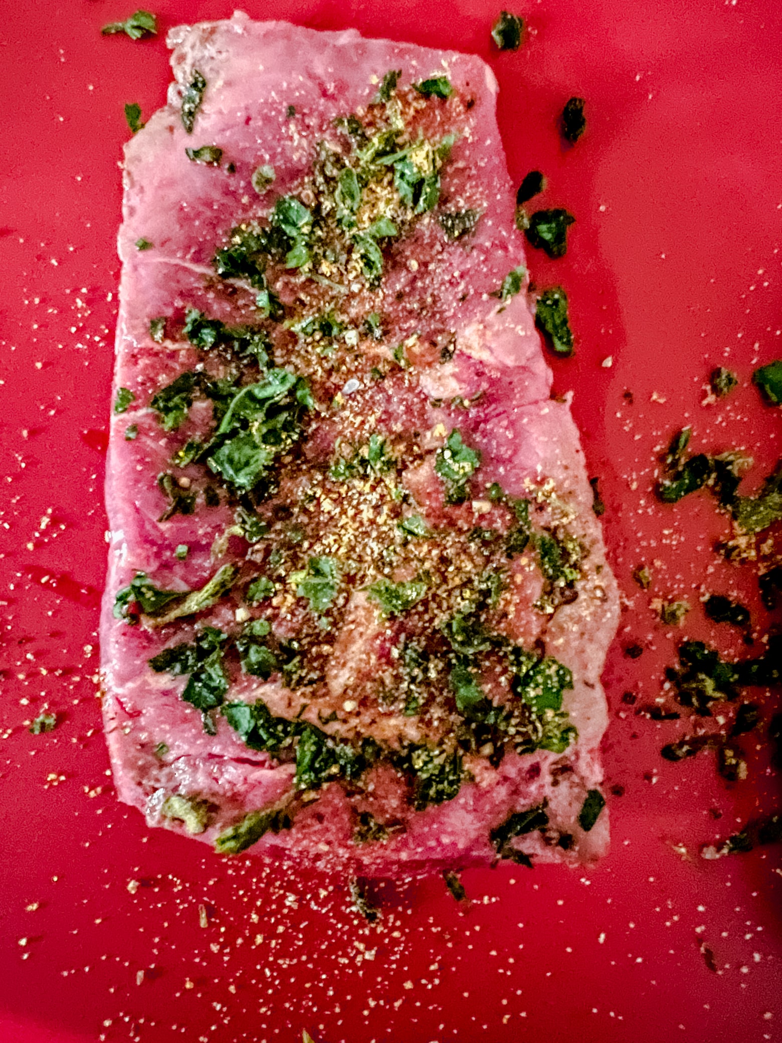 overhead view of a raw flat iron steak that has been seasoned