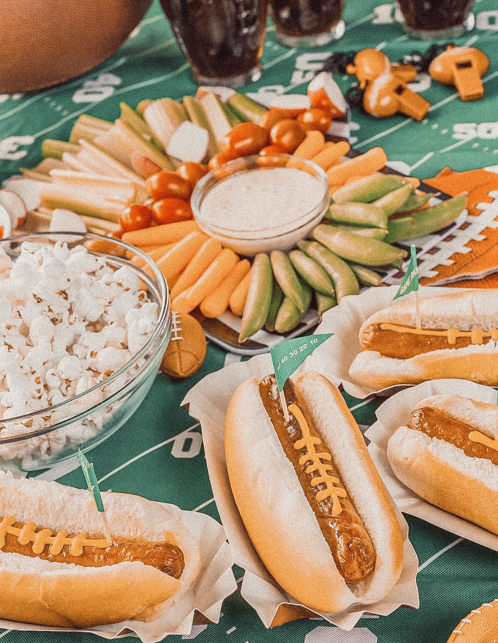 Overhead view of a gameday food spread on a football themed table